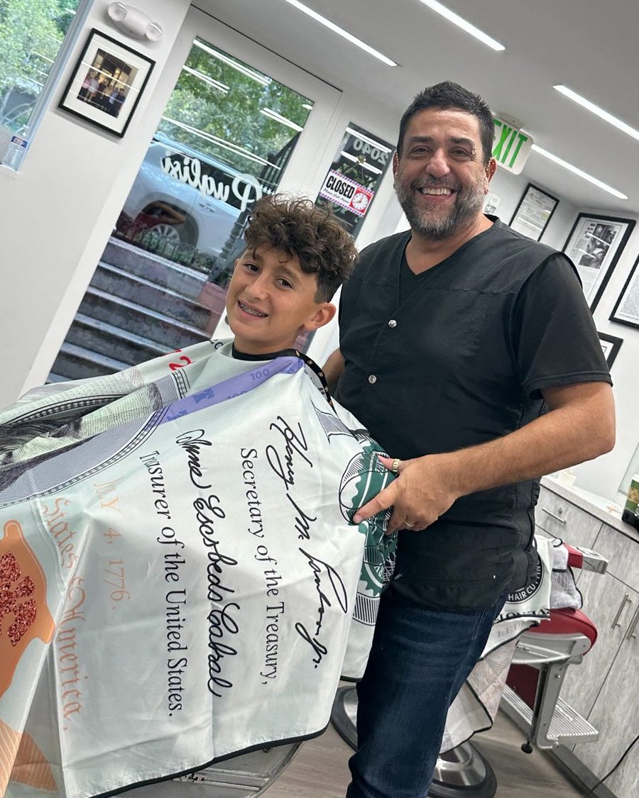 A barber grinning with a boy in the chair at Puglisi